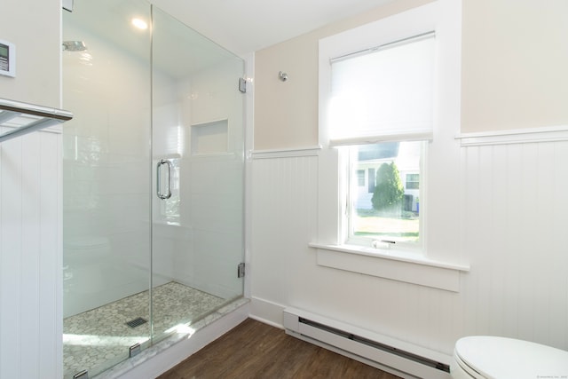 bathroom with hardwood / wood-style flooring, a baseboard radiator, toilet, and a shower with door