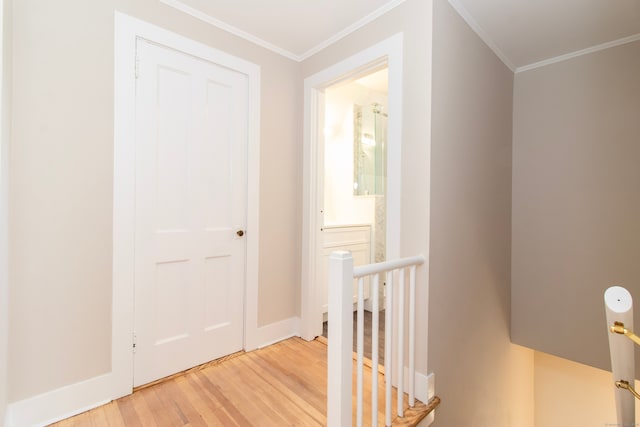 hall with ornamental molding and light wood-type flooring