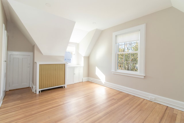 bonus room with lofted ceiling, light hardwood / wood-style flooring, and a wealth of natural light