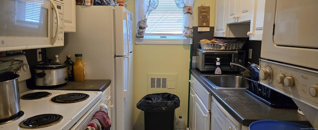 kitchen featuring sink, white cabinets, and white appliances