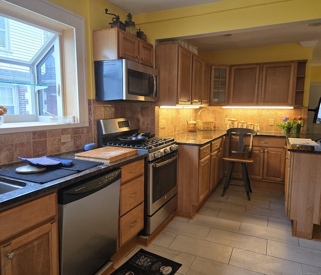 kitchen featuring light tile patterned flooring, appliances with stainless steel finishes, and tasteful backsplash