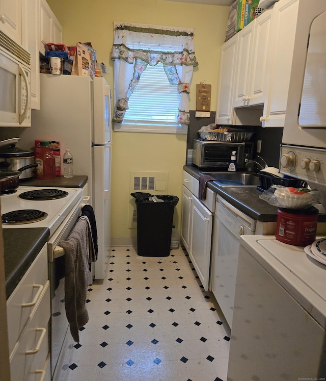 kitchen with sink, white appliances, and white cabinetry