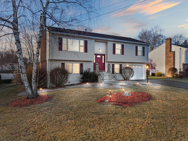 bi-level home featuring a lawn and a garage