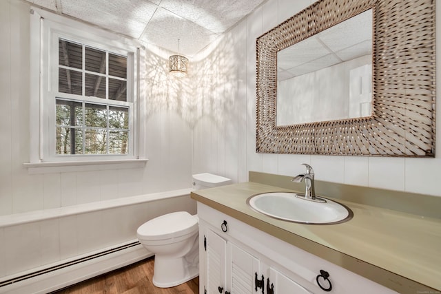 bathroom with baseboard heating, toilet, vanity, and hardwood / wood-style flooring