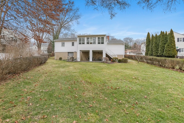 rear view of property featuring a lawn