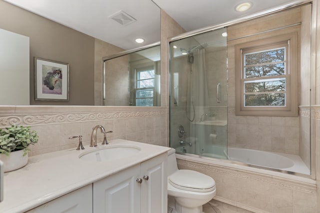 full bathroom featuring shower / bath combination with glass door, toilet, and vanity