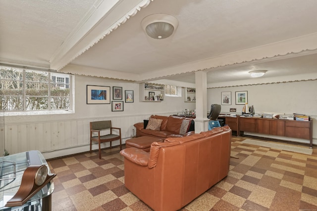 living room featuring a textured ceiling, wooden walls, and a baseboard heating unit