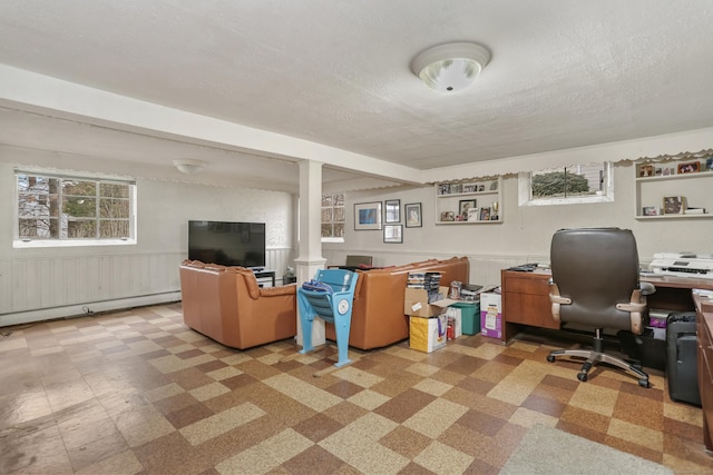 office space featuring a textured ceiling, a baseboard radiator, and a wealth of natural light