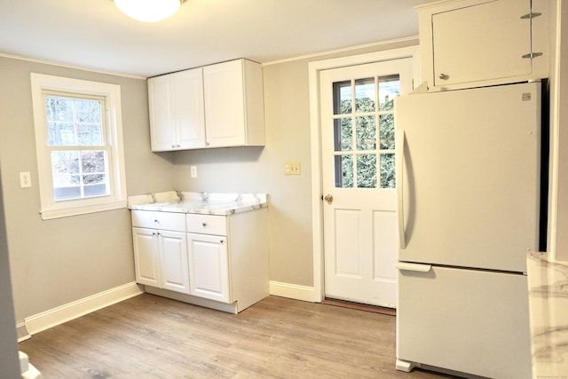 kitchen featuring white cabinets, a wealth of natural light, and white refrigerator