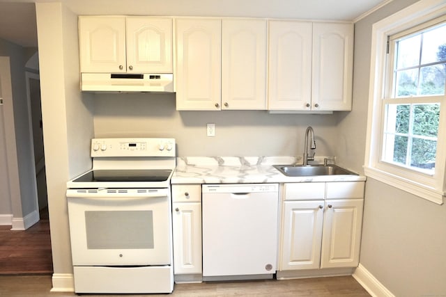 kitchen with white cabinets, sink, white appliances, and light hardwood / wood-style floors