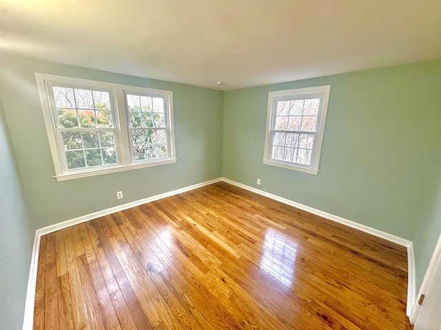 unfurnished room featuring plenty of natural light and hardwood / wood-style floors