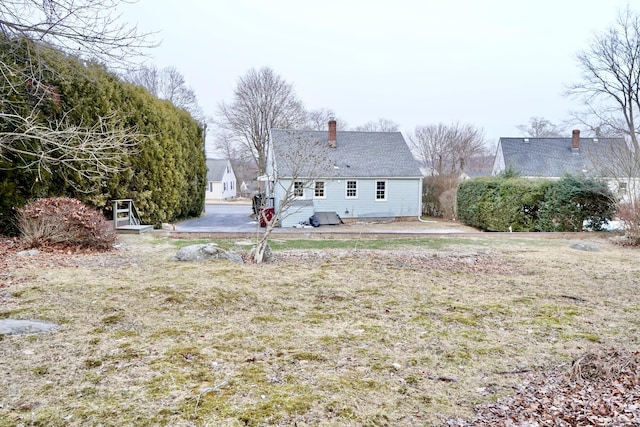 rear view of property featuring a lawn