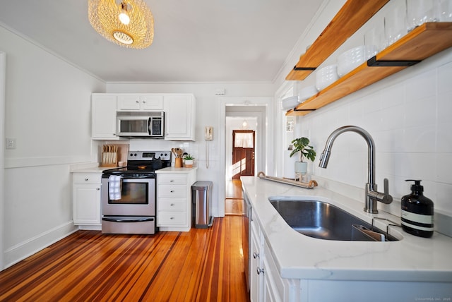 kitchen with white cabinetry, sink, stainless steel appliances, tasteful backsplash, and pendant lighting