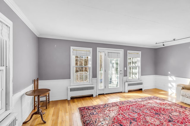 interior space featuring hardwood / wood-style flooring, radiator, and ornamental molding