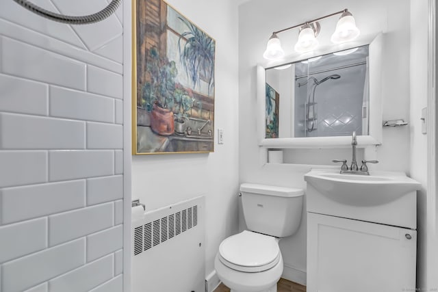 bathroom with radiator heating unit, vanity, and toilet