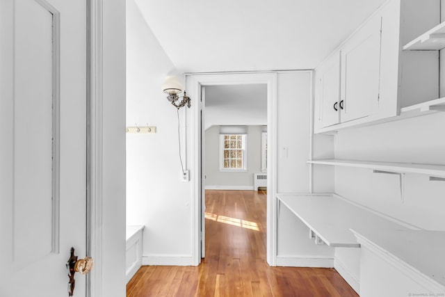 corridor with light hardwood / wood-style floors and radiator