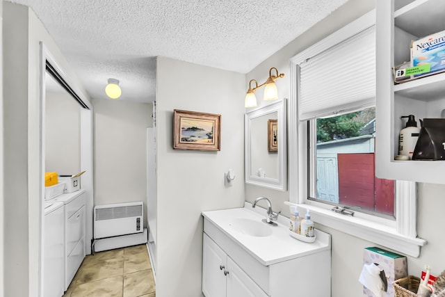 bathroom featuring tile patterned floors, a textured ceiling, vanity, heating unit, and washing machine and clothes dryer