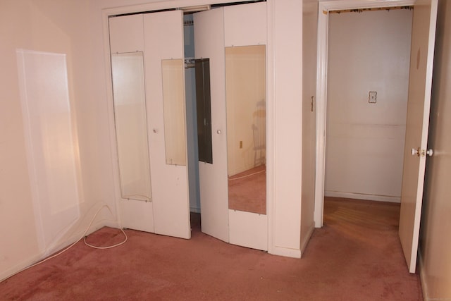 unfurnished bedroom with light colored carpet and a closet