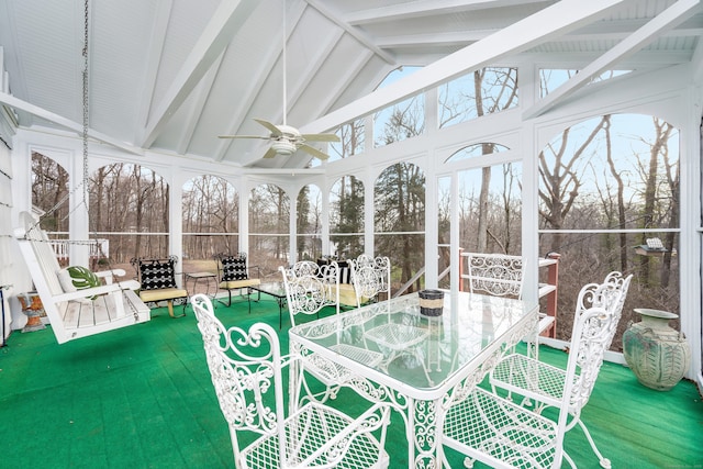 sunroom with ceiling fan and vaulted ceiling with beams