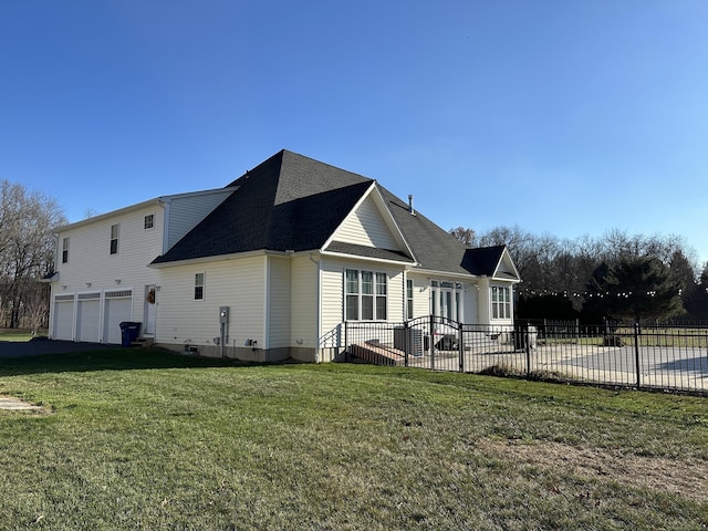 rear view of property with a yard and a garage