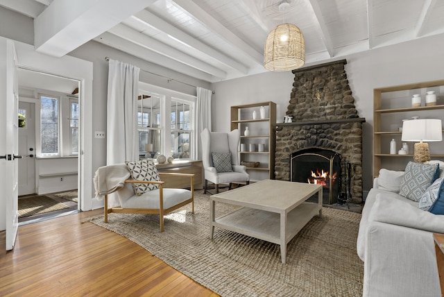 living room with beam ceiling, a brick fireplace, wood ceiling, and hardwood / wood-style floors