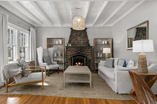 living room with hardwood / wood-style flooring, beamed ceiling, and a fireplace