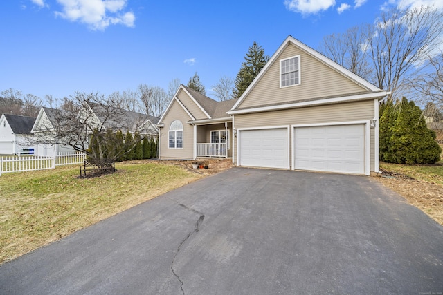 view of front property featuring a garage, covered porch, and a front yard