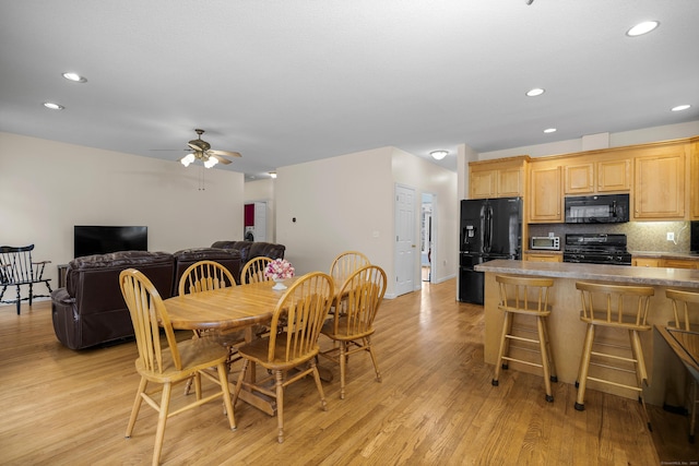 dining space with light hardwood / wood-style flooring and ceiling fan