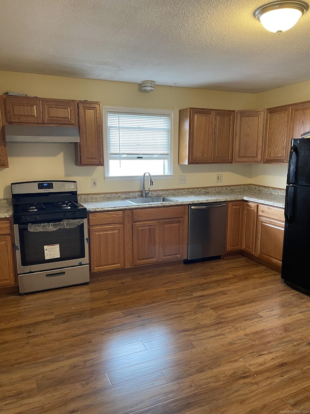 kitchen with a textured ceiling, dark hardwood / wood-style floors, sink, and appliances with stainless steel finishes