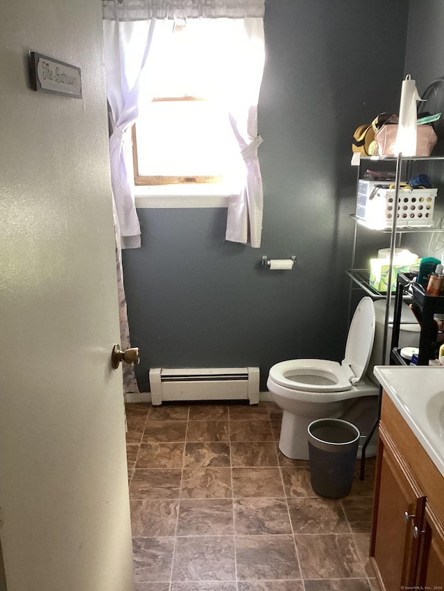 bathroom featuring baseboard heating, vanity, and toilet