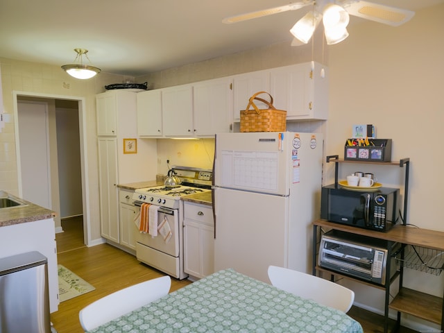 kitchen with white cabinetry, light hardwood / wood-style floors, ceiling fan, tasteful backsplash, and white appliances