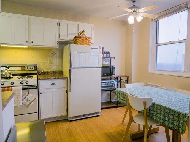 kitchen featuring light wood-type flooring, decorative backsplash, white cabinets, and white appliances