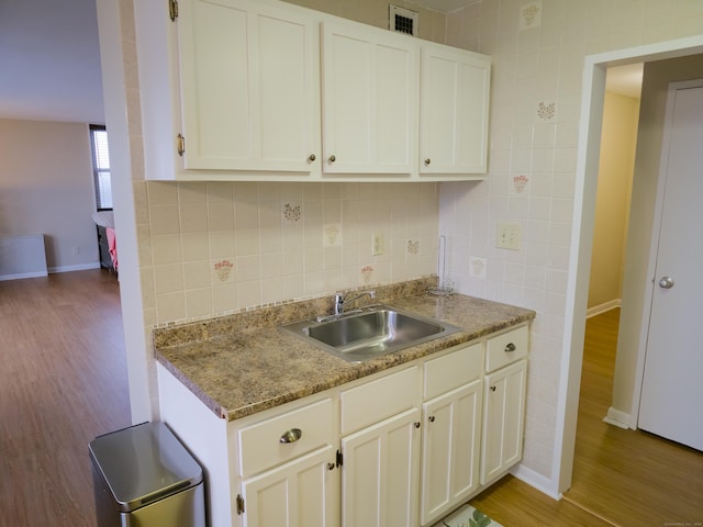 kitchen with sink, white cabinetry, and light wood-type flooring