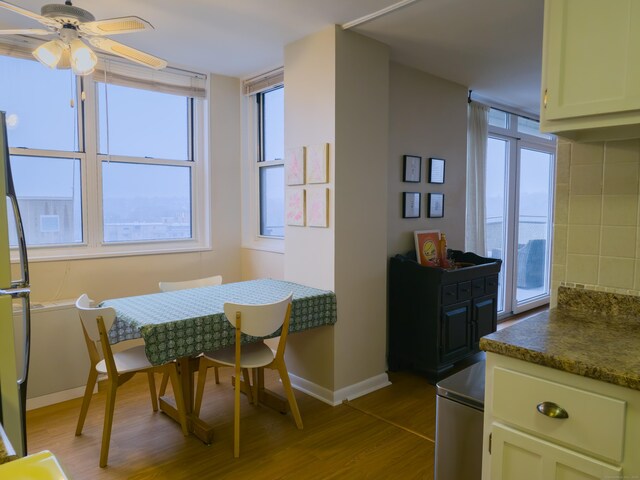 dining area with ceiling fan and wood-type flooring