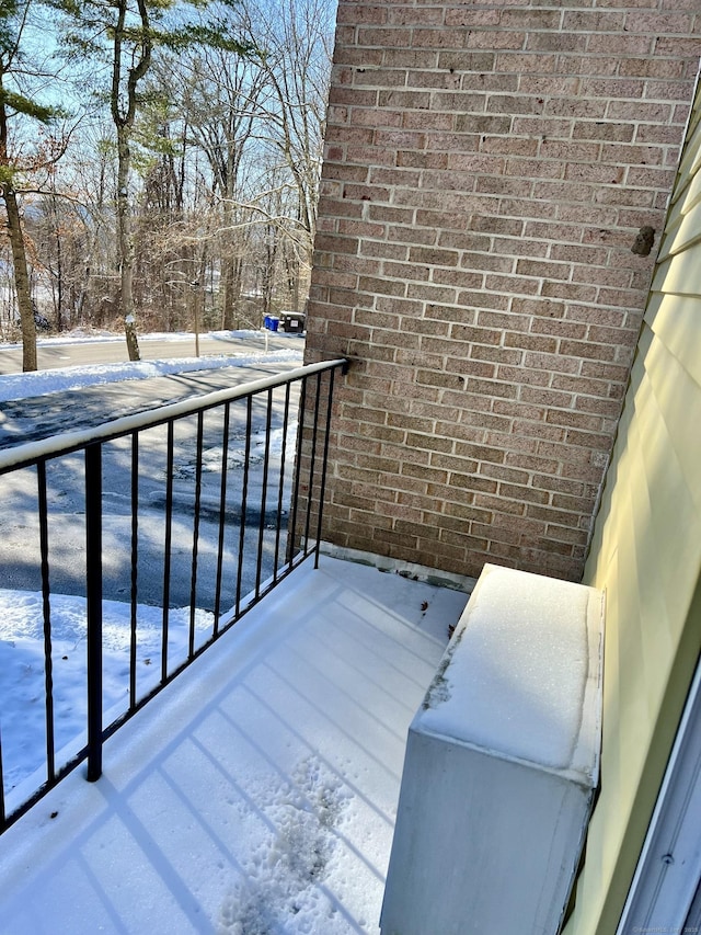 view of snow covered back of property