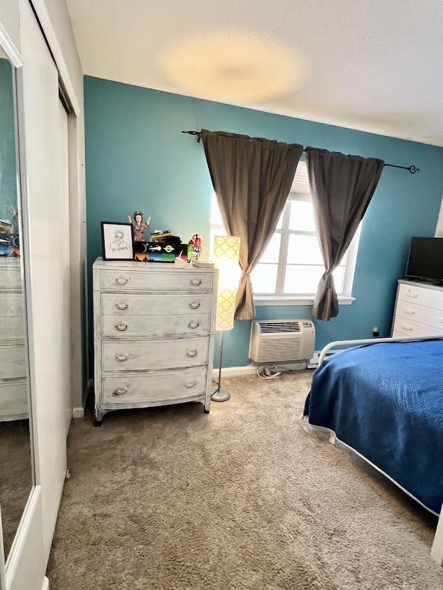 bedroom with a wall mounted air conditioner, carpet floors, and a closet