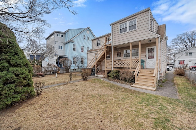 back of house featuring covered porch and a lawn