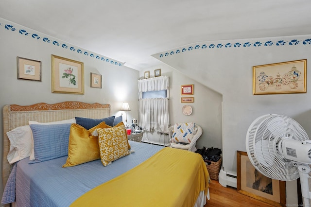 bedroom with hardwood / wood-style flooring and baseboard heating