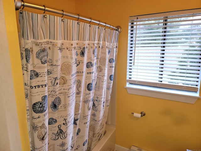 bathroom with shower / bath combo with shower curtain