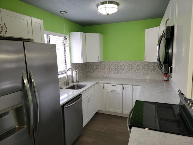 kitchen with pendant lighting, white cabinetry, sink, and stainless steel appliances