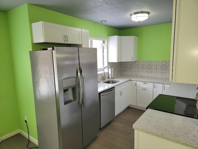 kitchen featuring hanging light fixtures, white cabinetry, sink, and appliances with stainless steel finishes