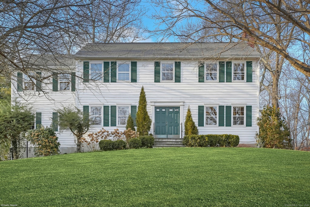 colonial house featuring a front lawn