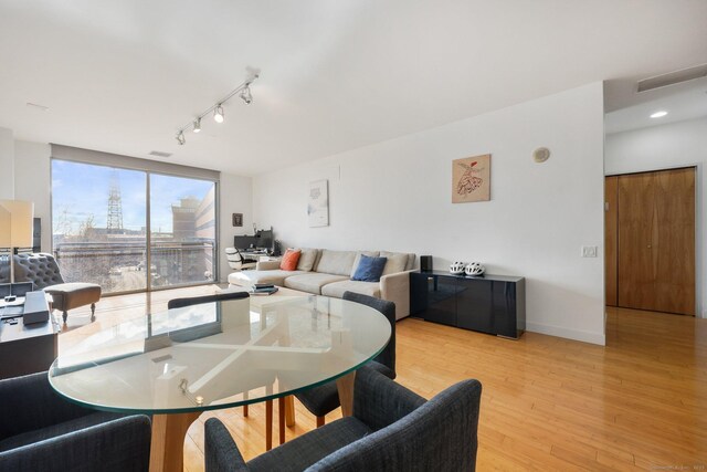 dining area featuring rail lighting and light hardwood / wood-style flooring