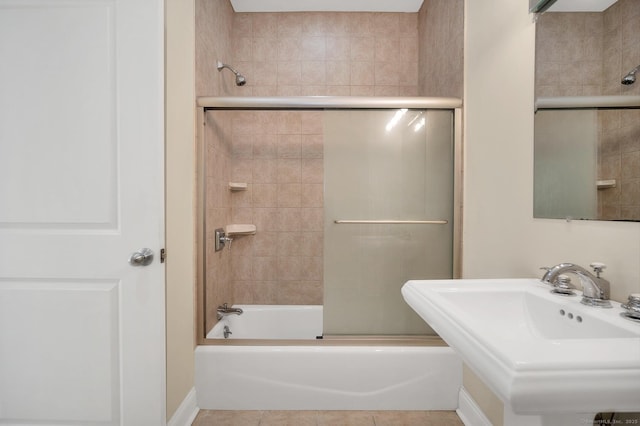 bathroom with tile patterned flooring, enclosed tub / shower combo, and sink