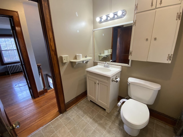 bathroom with vanity, toilet, and radiator