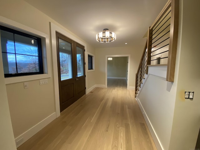 entryway with an inviting chandelier and light hardwood / wood-style floors