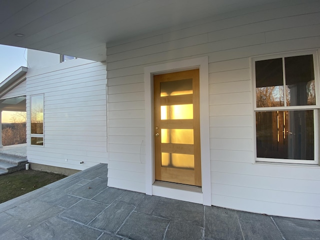 view of exterior entry with a patio