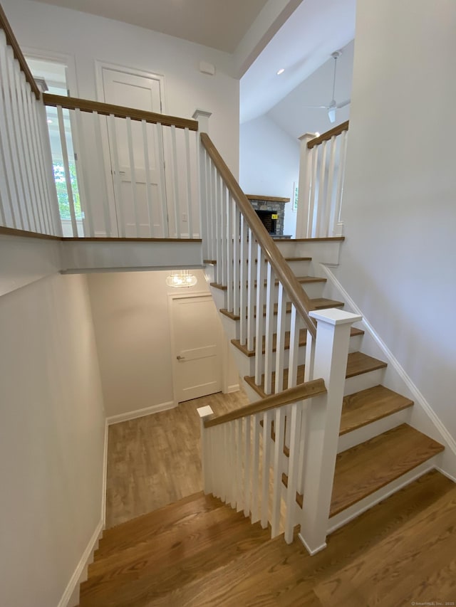 staircase with ceiling fan and hardwood / wood-style floors