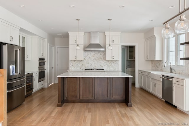 kitchen with white cabinetry, appliances with stainless steel finishes, wall chimney range hood, and wine cooler