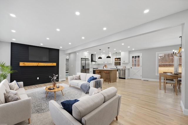 living room featuring sink, a chandelier, and light wood-type flooring